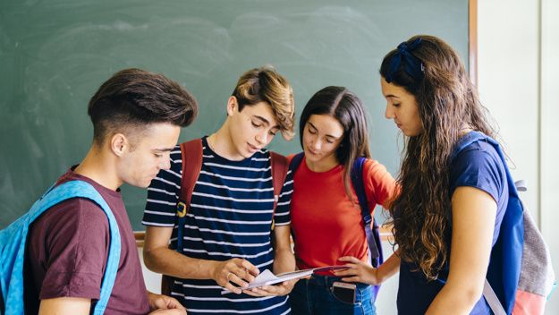 cuatro-ninos-de-colegio-en-sala-de-clase_23-2147667414